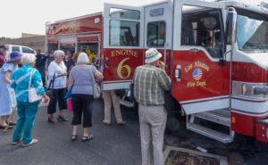 A group of people standing around a fire truck.