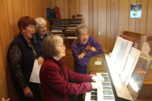 A group of women are playing piano together.