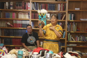 A man holding up an object in front of another person.