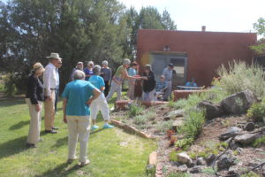 A group of people standing around in the grass.