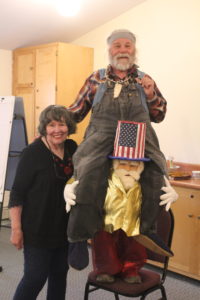 A woman and man standing next to an old man.