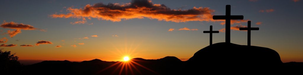 A sunset with the sun setting over mountains.